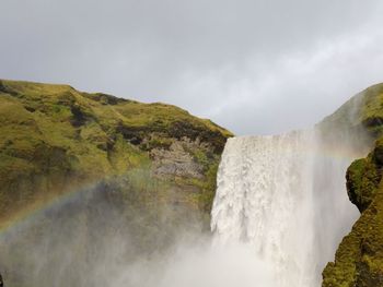 Scenic view of waterfall against sky