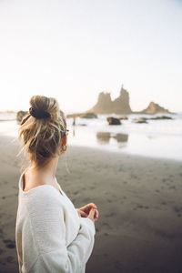 Side view of woman looking at sea against sky