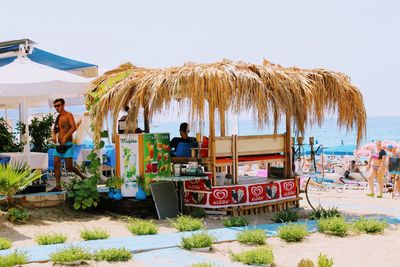 People on beach against clear sky