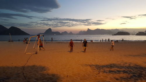 People at beach during sunset