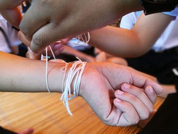 Close-up of hands tying thread