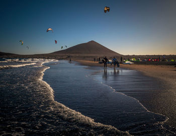 People at beach against sky