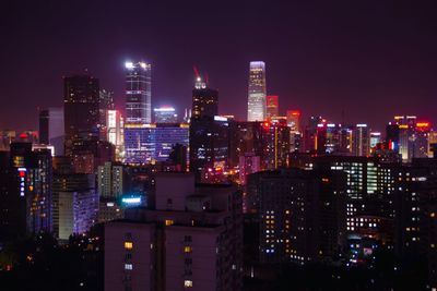 Illuminated cityscape against sky at night