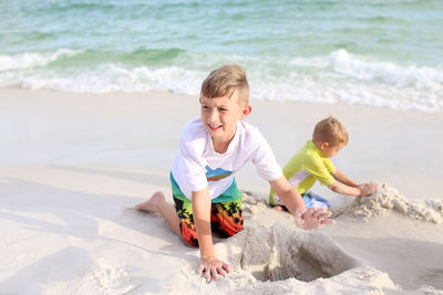 Brothers making sandcastles at beach