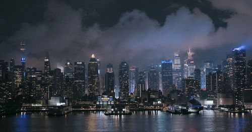 Illuminated buildings in city against sky at night