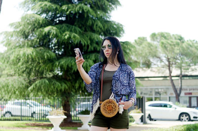 Young happy business woman relaxing in city, park. using phone. selfie. technology. summer vacation