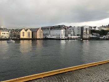 River by buildings in city against sky