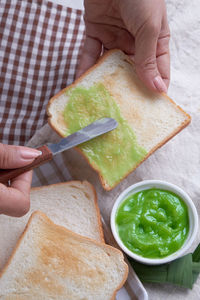 Cropped hand spreading dip on toasted bread