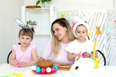 Mother and daughter sitting on table