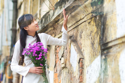 Side view of couple standing against wall