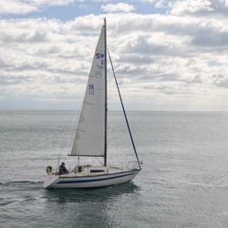 Sailboat sailing on sea against sky