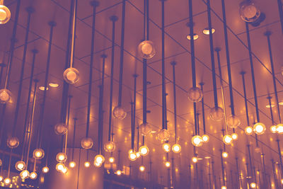 Low angle view of illuminated light bulbs hanging from ceiling