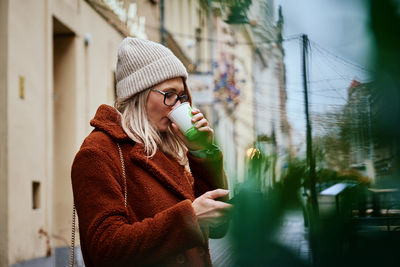 Woman at city street with coffee cup