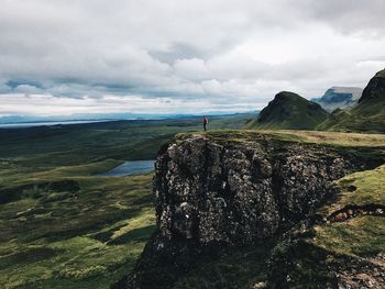 Man standing on cliff against sky