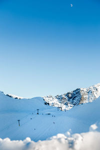 Snow covered mountain against blue sky