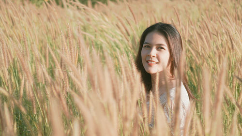 Portrait of smiling young woman lying on field