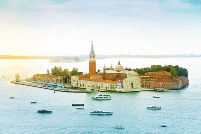 Boats in sea against buildings