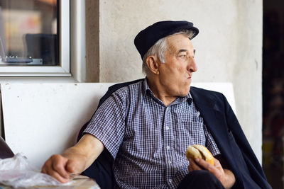 Man looking away while sitting on wall