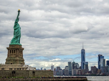 Statue of city against cloudy sky