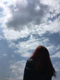 Low angle view of woman flying against sky