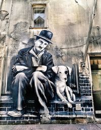 Statue of man sitting in front of building