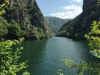 Scenic view of river and mountains against sky