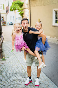 Happy father with daughters on road