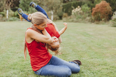 Young woman with arms raised on field