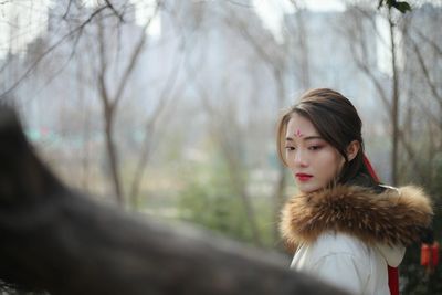 Thoughtful young woman wearing fur coat