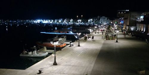 Illuminated harbor by buildings in city at night