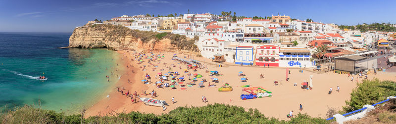 High angle view of people on beach against buildings in carvoeiro at the algarve coast