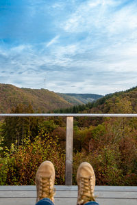 Low section of person sitting against mountains