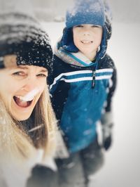 Portrait of smiling young woman with son in winter