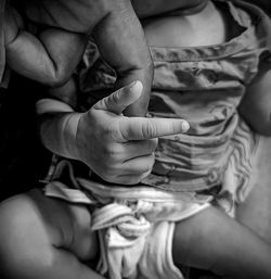 Close-up of  holding hand by baby girl of her father