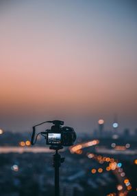 Close-up of illuminated lighting equipment on street at sunset