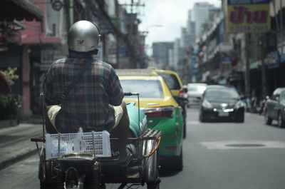 Rear view of man on motorcycle on road