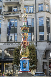 Low angle view of statue against building in city