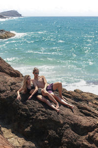 Young couple in swimsuits embracing on the cliffs of australia