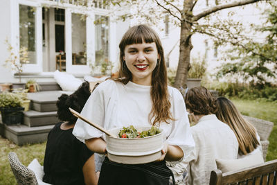 Portrait of smiling young woman eating food