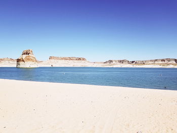Scenic view of beach against clear blue sky