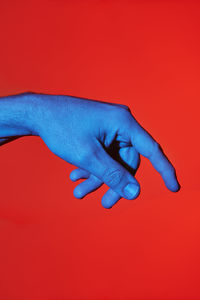 Close-up of human hand against red background