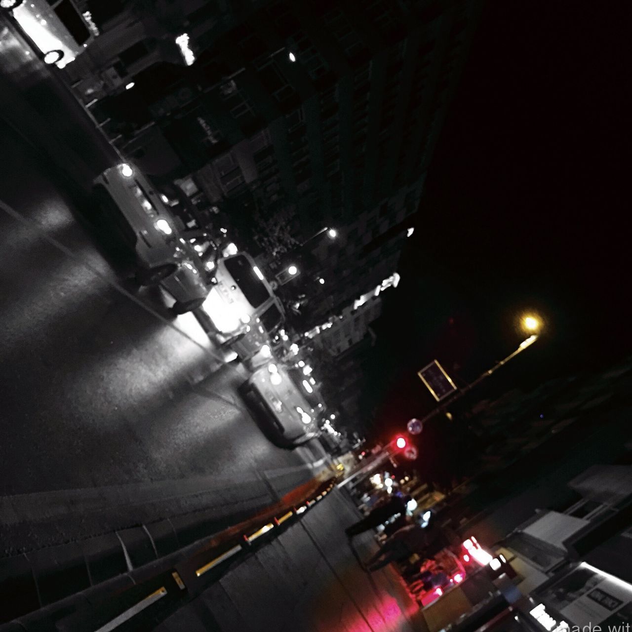 HIGH ANGLE VIEW OF ILLUMINATED STREET AND BUILDINGS IN CITY