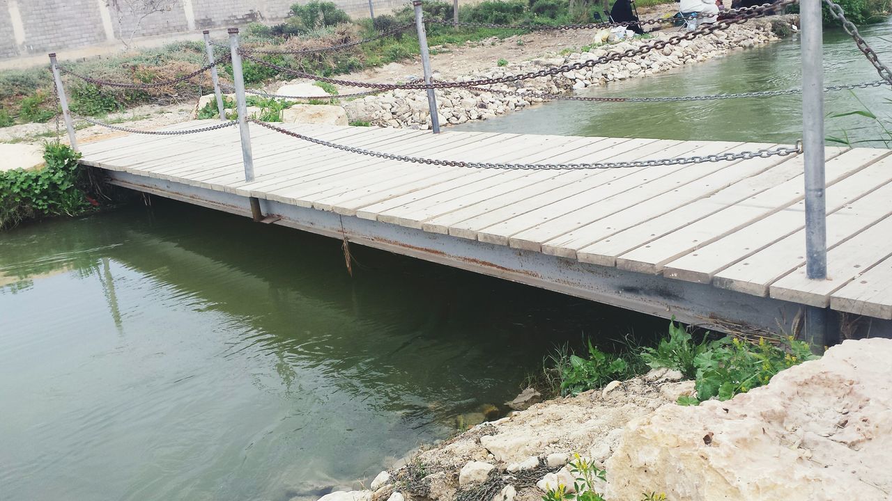 water, built structure, railing, architecture, river, bridge - man made structure, connection, reflection, high angle view, rippled, plant, day, canal, nature, outdoors, sunlight, waterfront, pond, bridge, lake