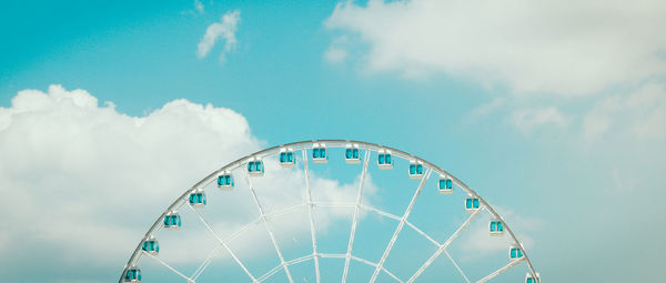 Low angle view of ferris wheel against blue sky