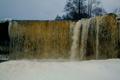 Scenic view of waterfall against sky