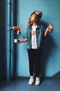 Young woman standing against wall