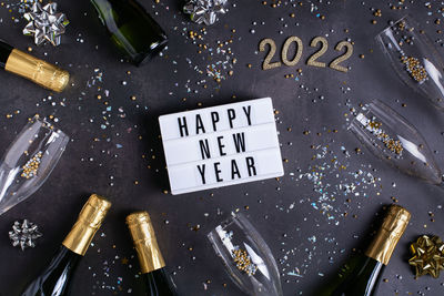 New year pattern with champagne glasses, bottles, sparkles, confetti and number of 2022. 