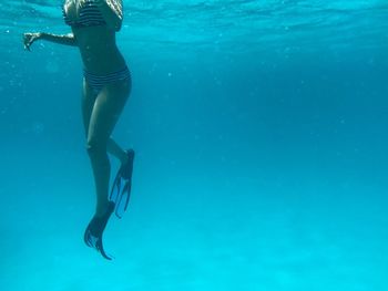 Low section of woman swimming in sea