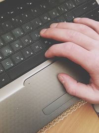 Cropped image of hand using laptop