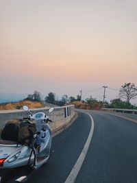 Cars on road against sky during sunset